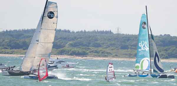 Windsurfer Guy Cribb competes against the Extreme 40s during Cowes Week 2010
